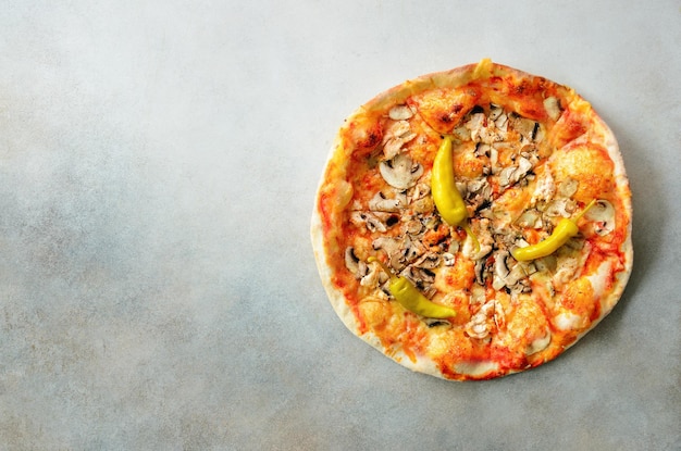 Fresh italian pizza with mushrooms ham tomatoes cheese olive pepper on grey concrete background Copy space Top view