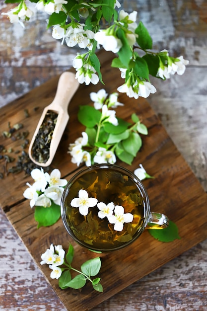 Photo fresh jasmine branches, seeds and tea