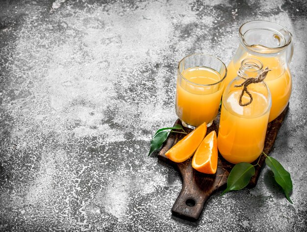 Fresh juice from ripe oranges . On rustic background.