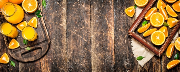 Fresh juice from ripe oranges. On wooden background.