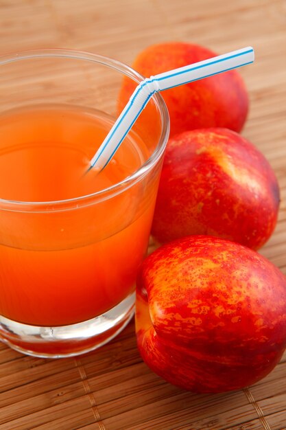 Photo fresh juice in a glass and peaches