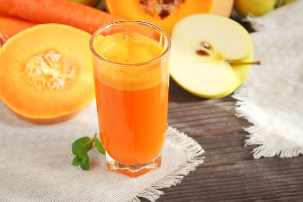 Свежий сок, смесь фруктов и овощей на деревянном столе