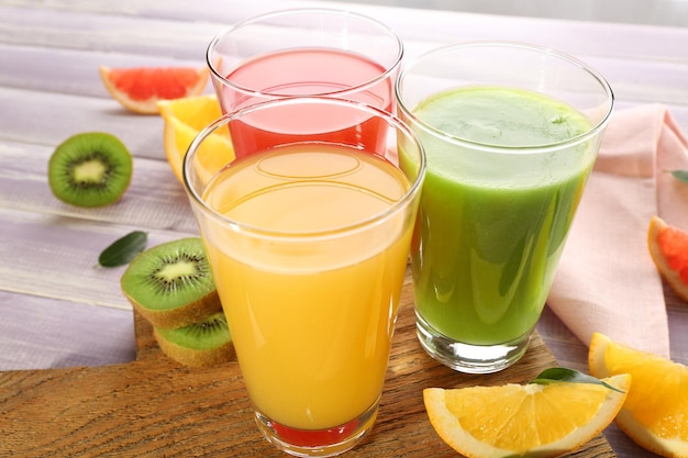 Fresh juices with fruits on wooden table