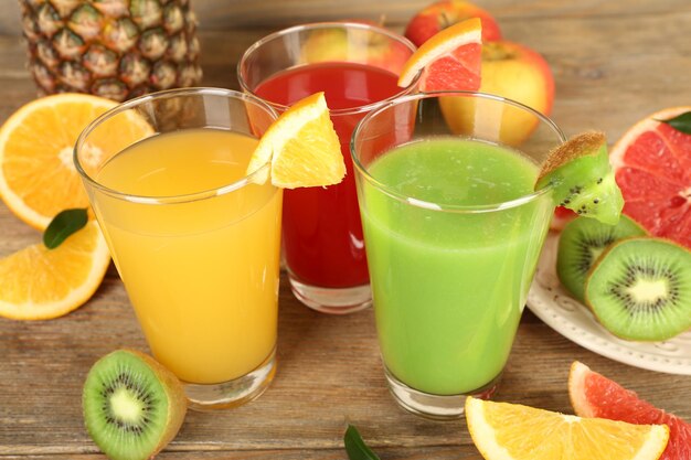 Fresh juices with fruits on wooden table