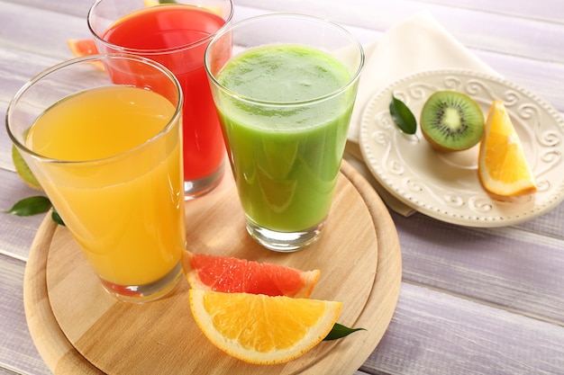 Fresh juices with fruits on wooden table