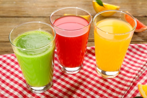 Fresh juices with fruits on wooden table