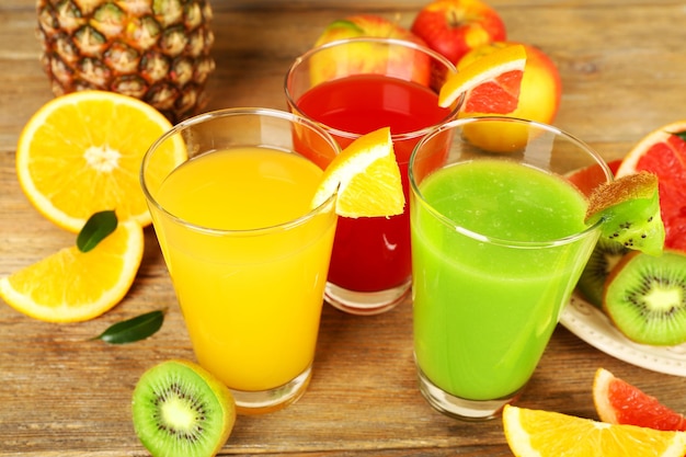 Photo fresh juices with fruits on wooden table