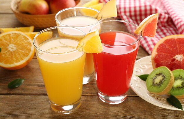 Fresh juices with fruits on wooden table