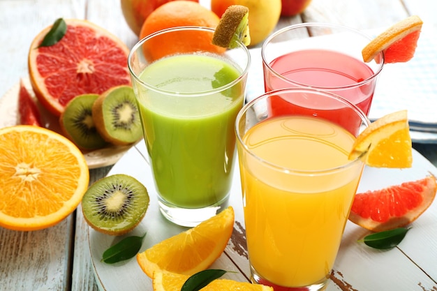 Fresh juices with fruits on wooden table