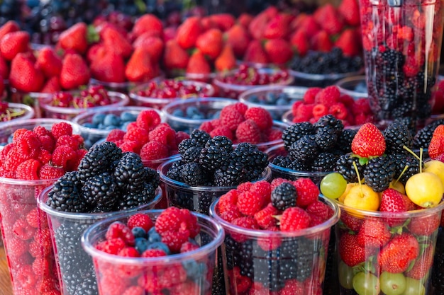 Fresh juicy berries on farmer market Colorful different fruit sets at street cafe