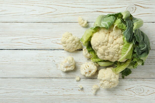 Photo fresh juicy cauliflower with slices on wooden background