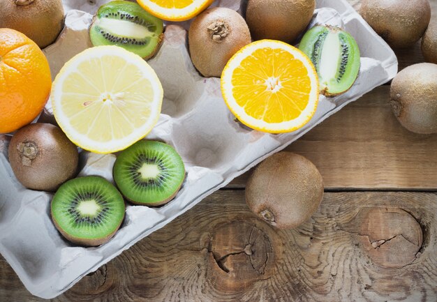 Fresh juicy citrus fruits in a box tray on  wooden surface