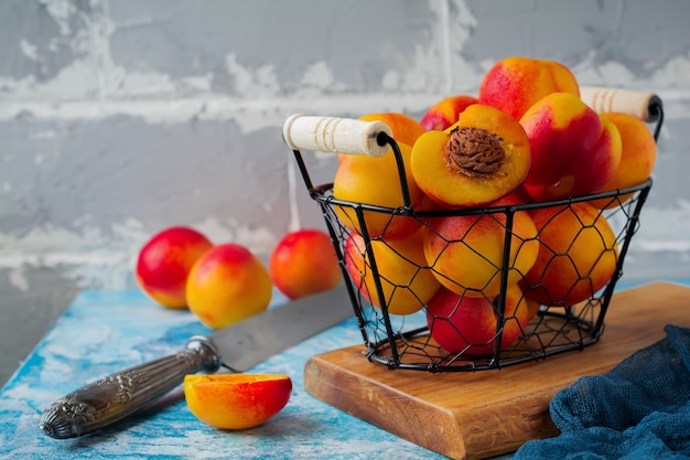 Fresh juicy fruit nectarines in metal grid on blue concrete.  