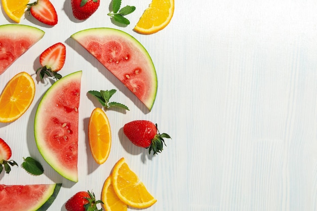 Photo fresh and juicy fruits on white wooden background