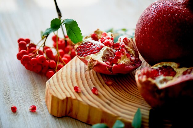 Fresh juicy pomegranate on a light background On the wooden end of it Next brush the ash Healthy eatingVegetarianism