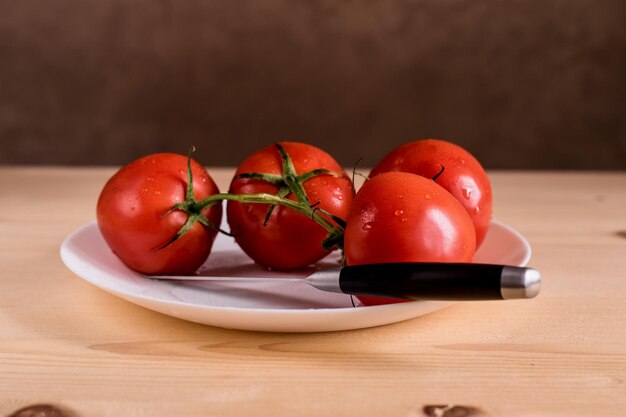 하얀 접시에 신선한 육즙이 많은 빨간 토마토