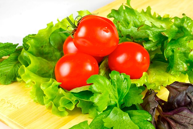 Fresh and juicy vegetables on the wood plate isolated