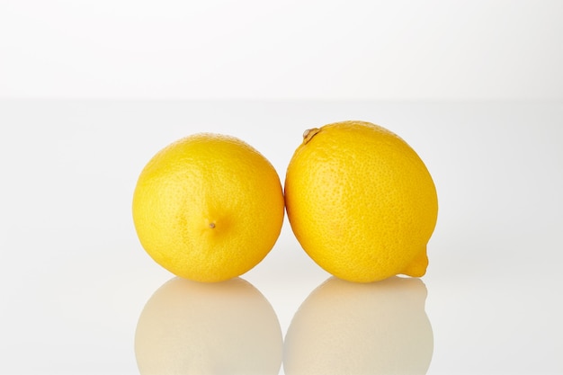 白い背景で隔離の新鮮なジューシーな黄色のレモンフルーツ。