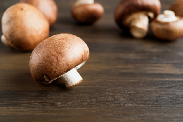 Fresh king brown mushrooms on wooden background.