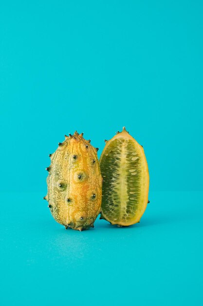 Fresh kiwano fruit jelly melon horned melon cut in half on blue background