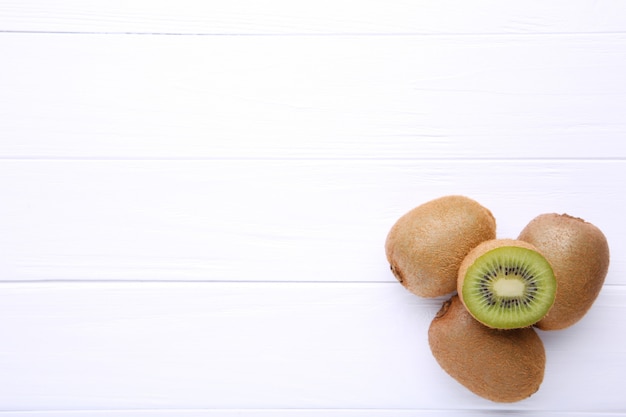 Fresh kiwi fruit on white wooden background