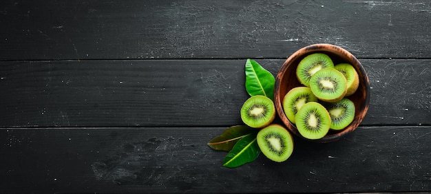 Fresh kiwi and green leaves on the table Rustic style Fruits Top view Free space for text