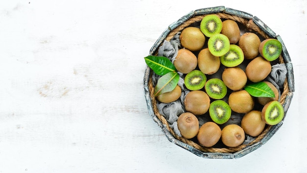 Fresh kiwi and green leaves in a wooden box on the old background Fruits Top view Free space for text