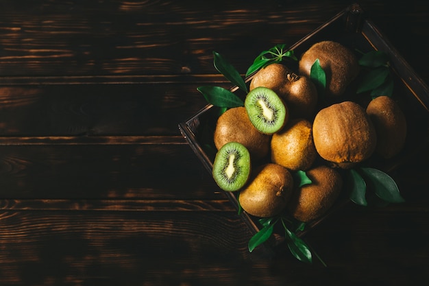 Fresh kiwi with green leaves in an wooden table