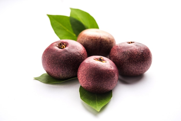 Fresh Kokum or Garcinia indica fruit from India isolated over white or in cane basket with leaves. selective focus