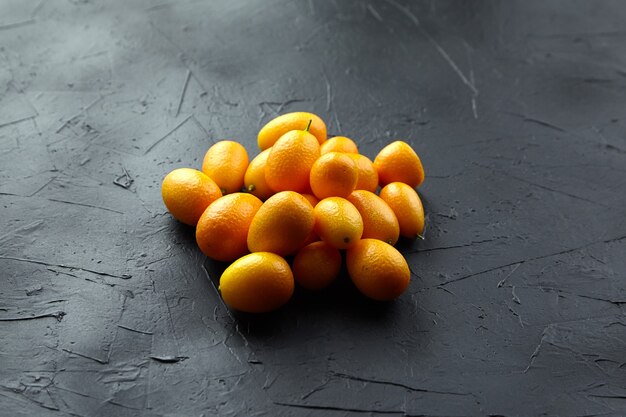 Agrumi freschi di kumquat sulla tavola di pietra nera