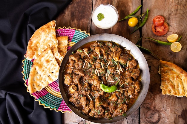 Foto agnello fresco karahi naan panno nero fondo di legno scuro