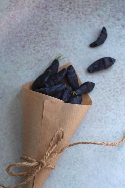 Fresh large honeysuckle berry in a paper envelope on a purple background