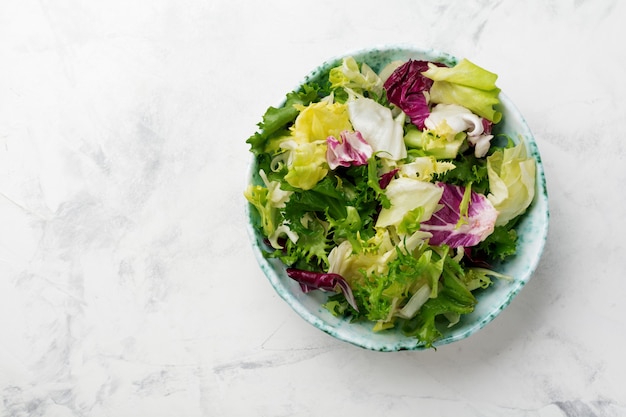 Foglie fresche di insalata diversa nel piatto di ceramica