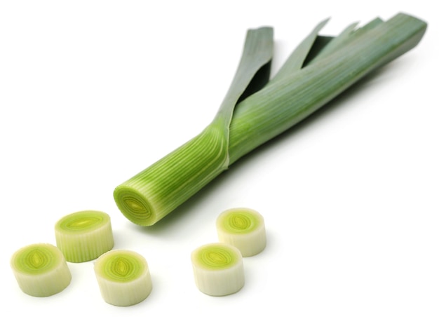 Fresh leek stems and leaves over white background