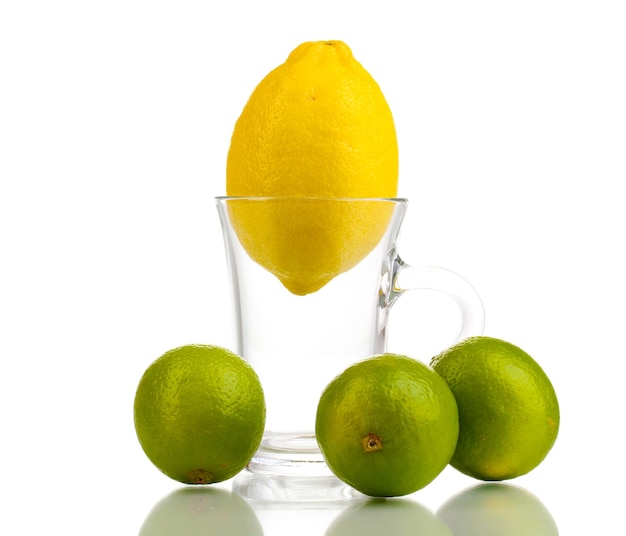 Fresh lemon in glass cup and limes isolated on white