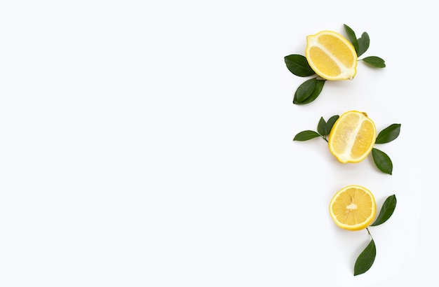 Fresh lemon with green leaves on white background.