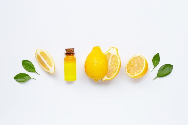 Fresh lemon with lemon essential oil on white.