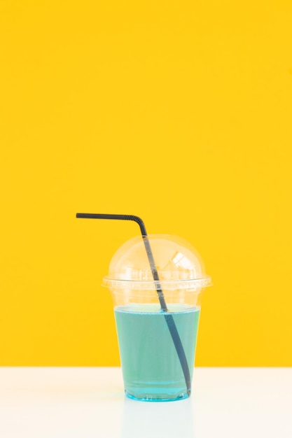 Fresh lemonade cocktail on color background Cocktail in plastic cup