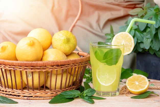 Fresh lemonade and lemons on wooden background