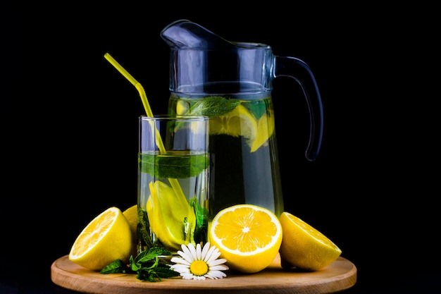 Fresh lemonade with lemon on wooden background