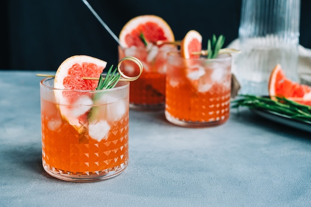 Fresh lemonade with rosemary and grapefruit in glass with ice, summer drink.