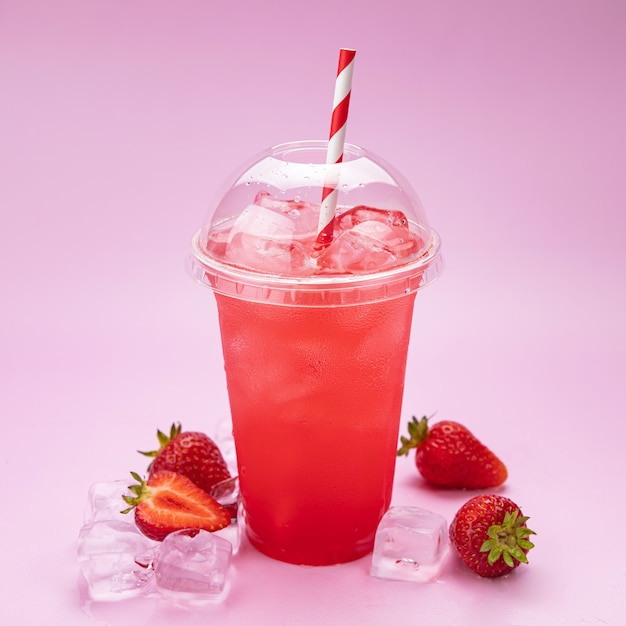 Fresh lemonade with strawberries in a plastic cup