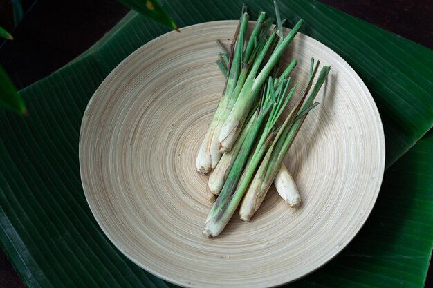 Fresh lemongrass cymbopogon citratus or citronella serai on a wooden plate