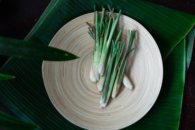 Photo fresh lemongrass cymbopogon citratus or citronella serai on a wooden plate