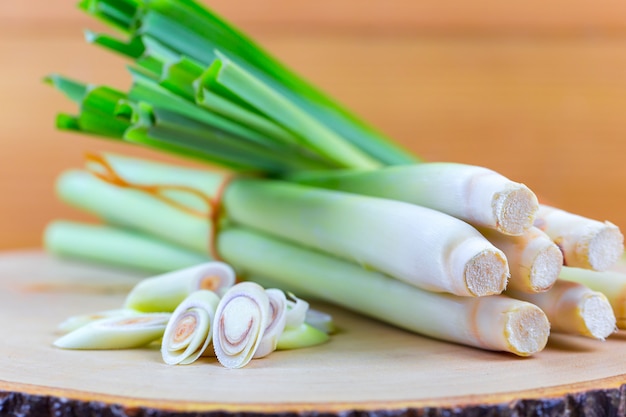 Fresh lemongrass rope and lemongrass slice on wooden cutting board in cooking concept.