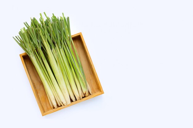 Fresh lemongrass in woodeb box on white.