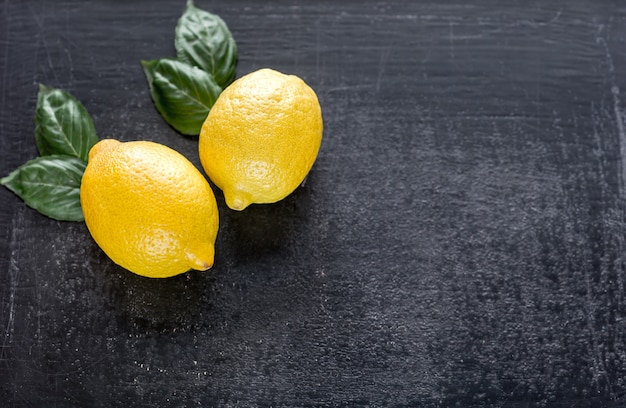 Fresh lemons on dark wooden