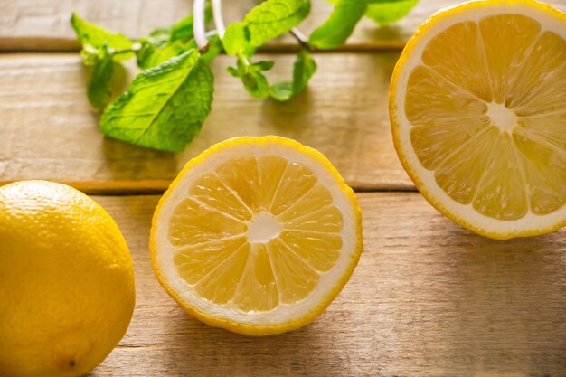 Fresh lemons and peppermint on wooden background