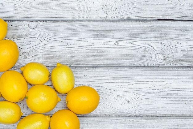 Fresh lemons on wooden table background