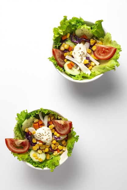 Fresh lettuce salad with tomatoes, red onion, corn, carrots, cucumber